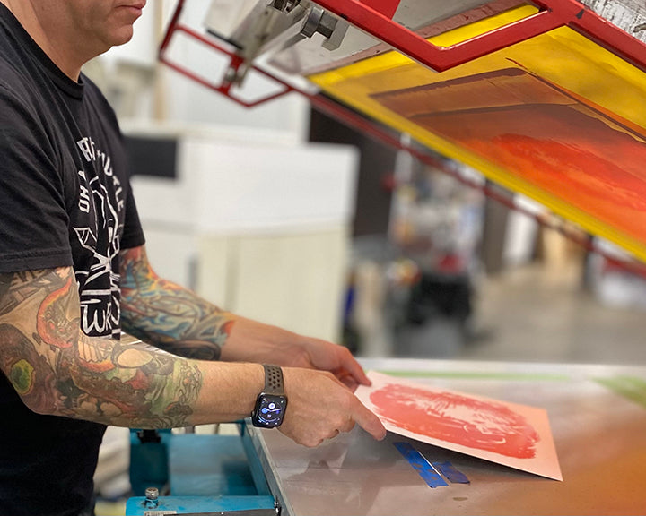 Adam Turman holding a piece of paper for printing - Turman Artwork Company